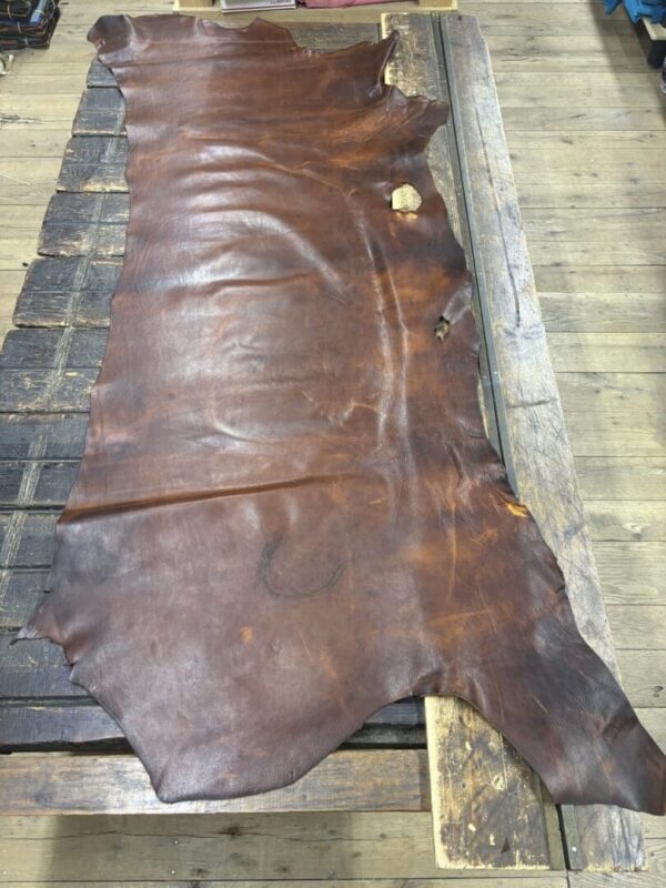 Brown leather hide on wooden table.