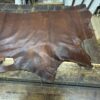 Brown leather hide on wooden table.
