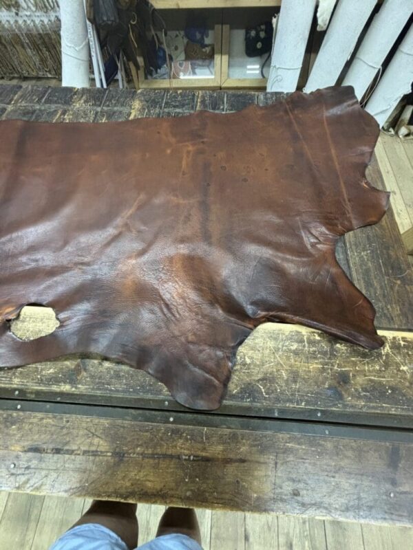Brown leather hide on wooden table.