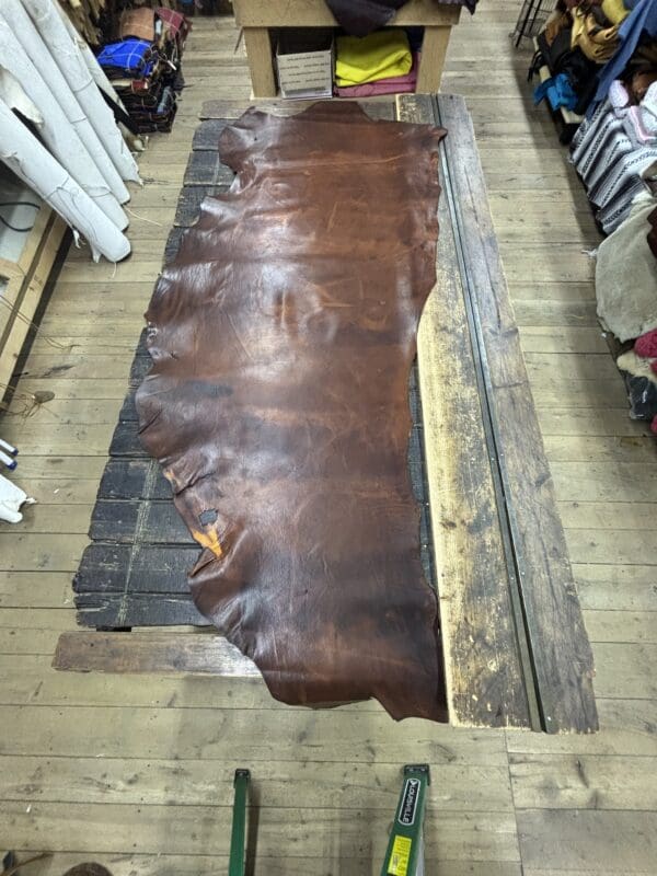 Large brown leather hide on table.