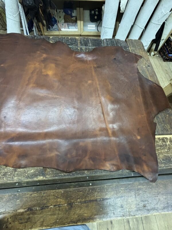 Brown leather hide on wooden table.