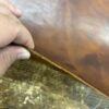 IMG_2664 Hand holding brown leather sheet.