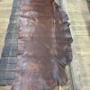 Brown leather hide on wooden table.