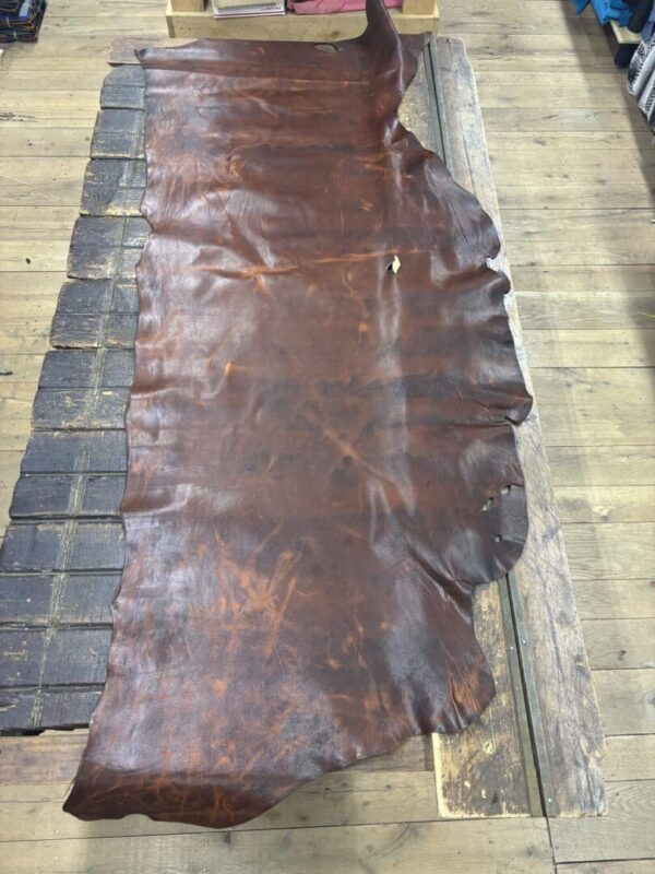 Brown leather hide on wooden table.