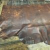 Brown leather hide on wooden table.