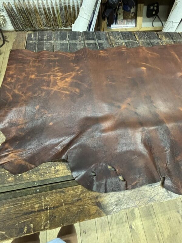 Brown leather hide on wooden table.