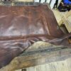 Brown leather hide on wooden table.