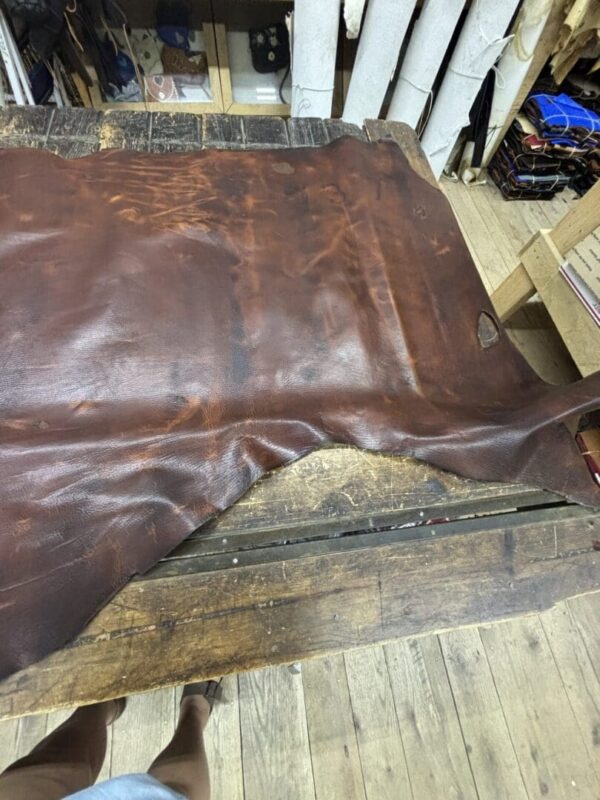 Brown leather hide on wooden table.