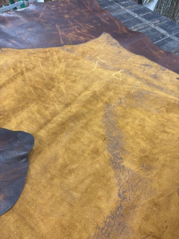 Brown and tan leather hides on a table.
