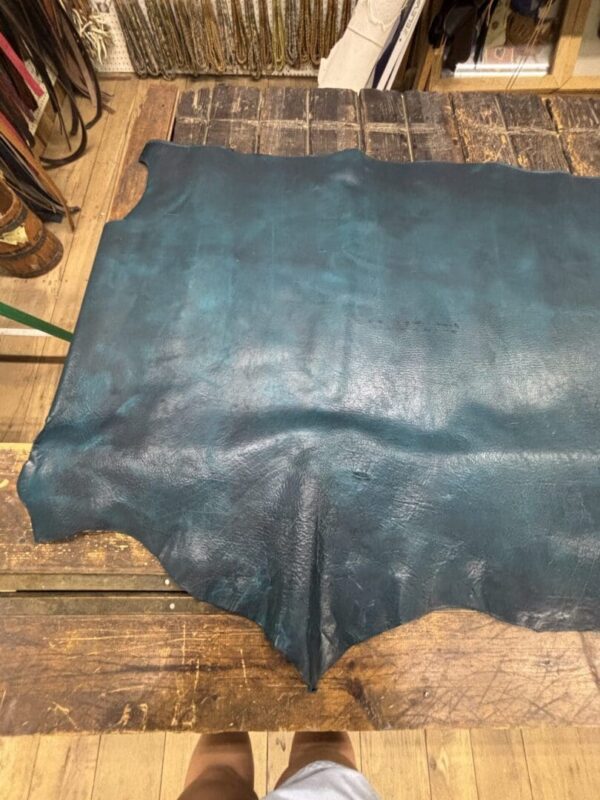 Teal leather hide on wood table.