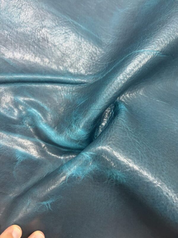 Textured turquoise leather material with hand.