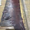 Dark brown leather hide on wooden table.