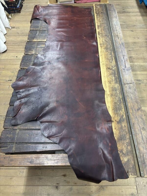 Dark brown leather hide on wooden table.