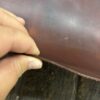 Hand holding a piece of brown leather.