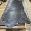 Large dark brown leather hide on wood table.