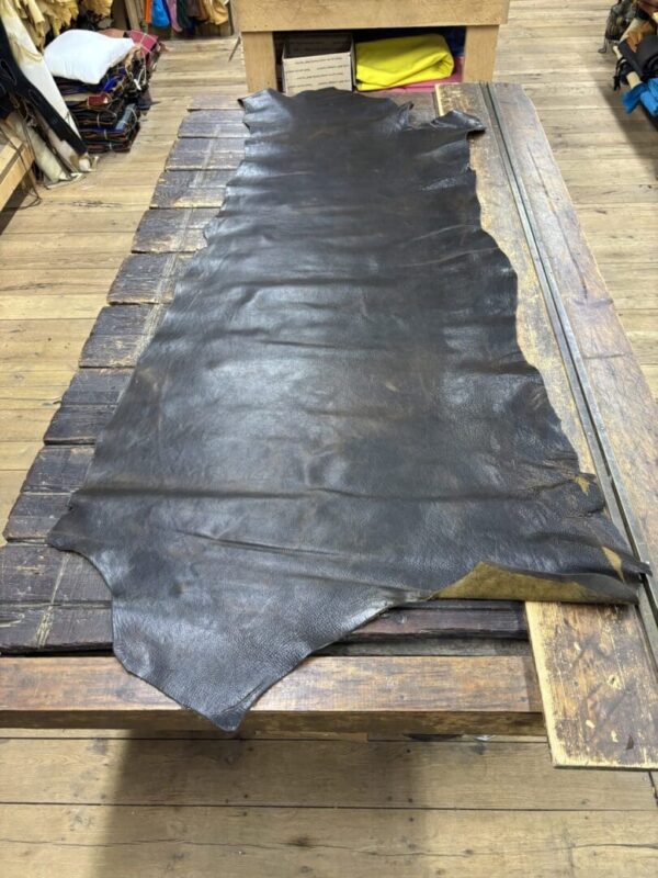 Large dark brown leather hide on wood table.