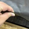 Hand holding a piece of leather.