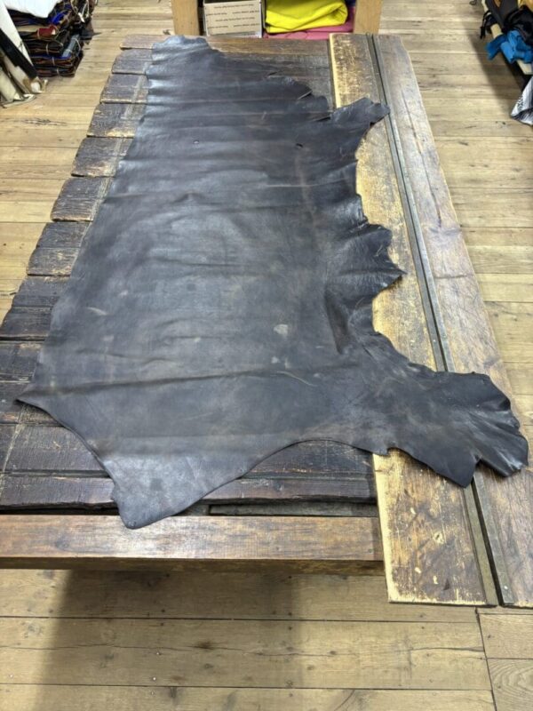 Dark brown leather hide on wood table.