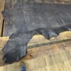 Large black leather hide on wooden surface.
