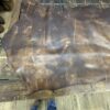 Brown leather hide on wooden table.