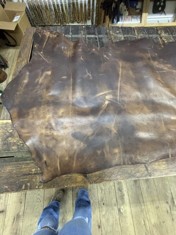 Brown leather hide on wooden table.