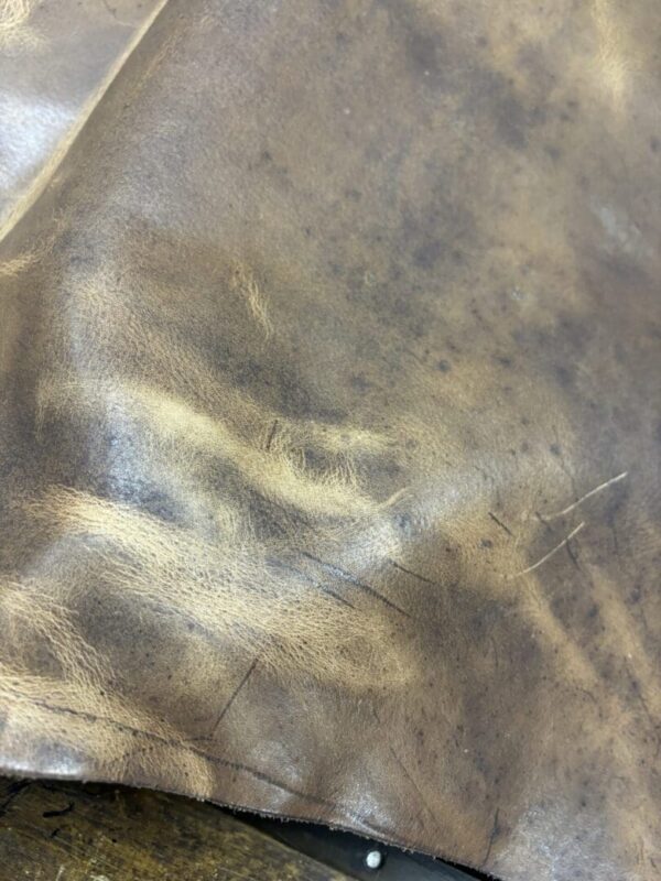 Close up of brown leather with scratches.