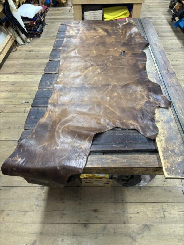 Large brown leather hide on wood table.