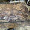 Large piece of brown leather on wood table.