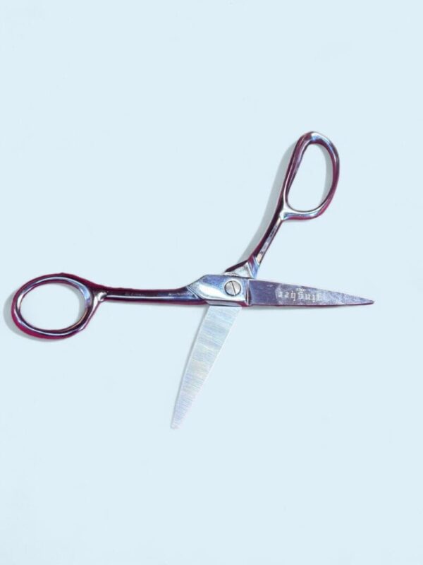 Open silver scissors on white background.