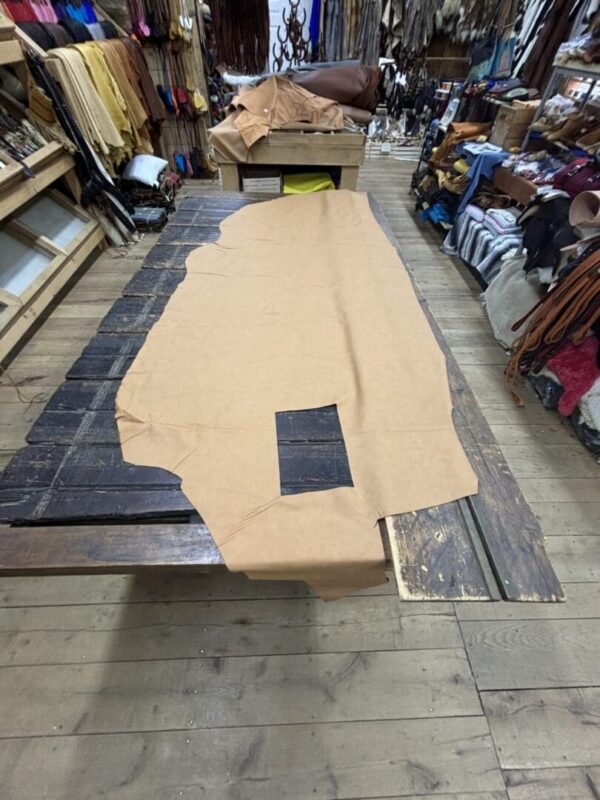 Brown leather hide on wooden table.