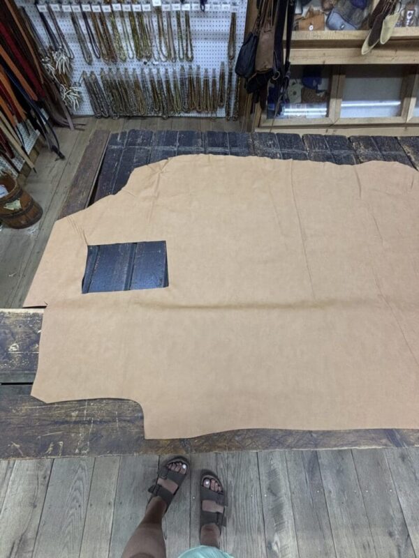 Tan leather sheet on a wooden floor.