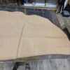 Tan leather hide on wooden table.