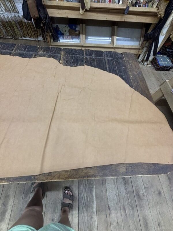 Tan leather hide on wooden table.