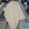 Tan leather hide on wooden surface.