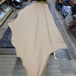 IMG_3059 Tan leather hide on wooden surface.