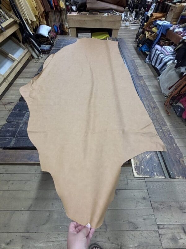 Tan leather hide on wooden surface.