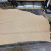 Tan leather hide on wooden table.
