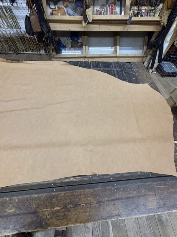 Tan leather hide on wooden table.