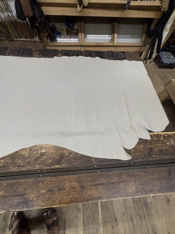 Off-white leather hide on wooden table.