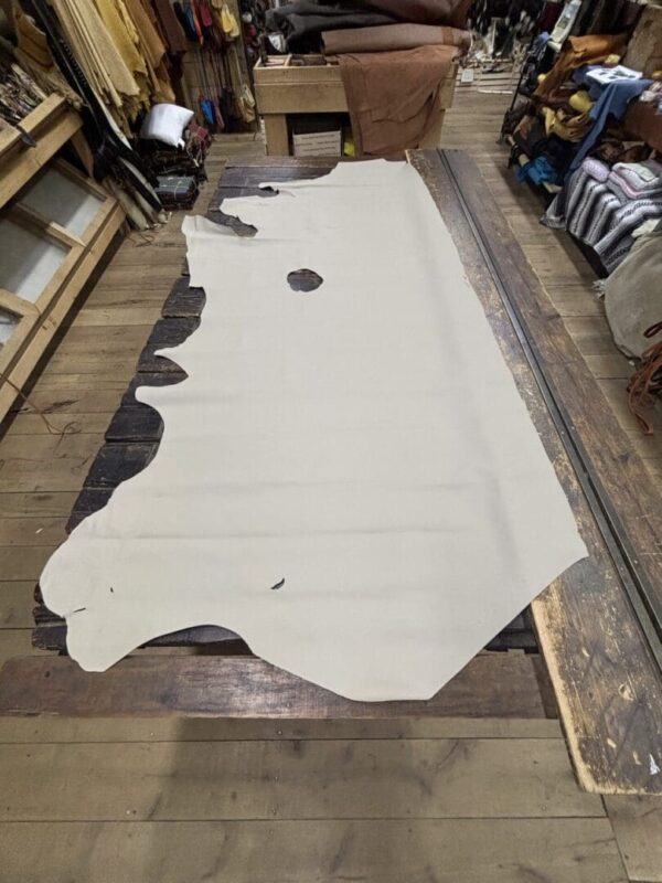 Tan leather hide on wooden table.