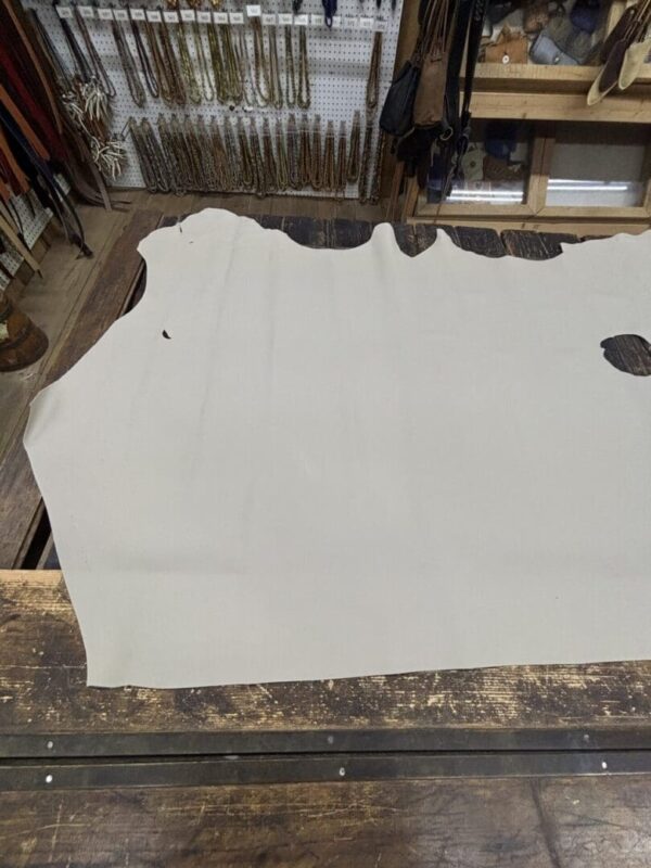 White leather hide on wooden surface.