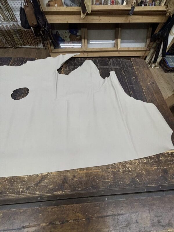 Large off-white leather hide on table.