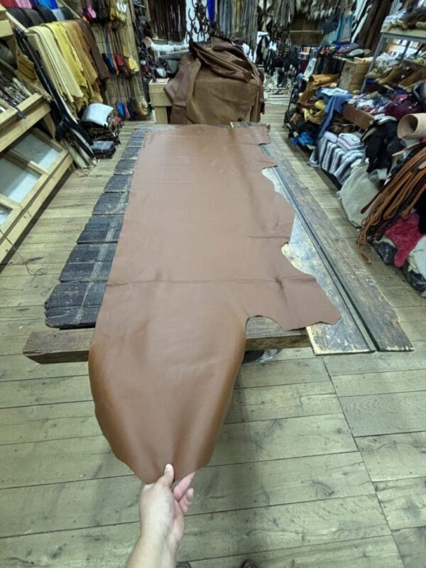 Brown leather hide on wooden table.