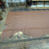 Brown leather sheet on wooden table.