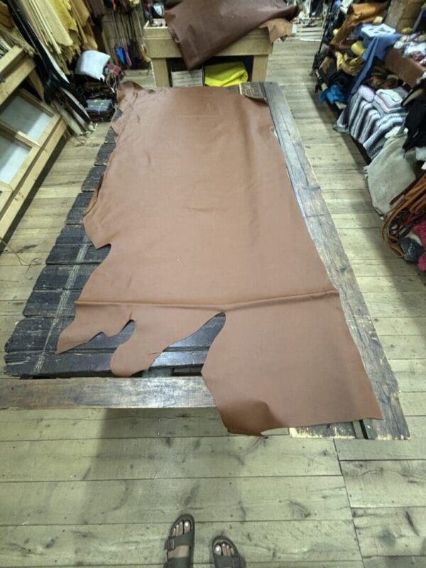 Brown leather hide on wooden table.