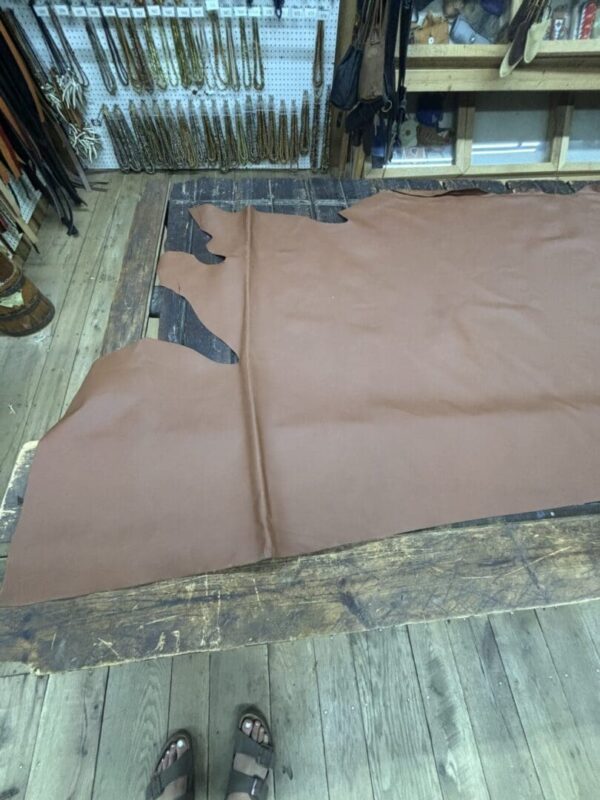 Brown leather hide on wooden table.