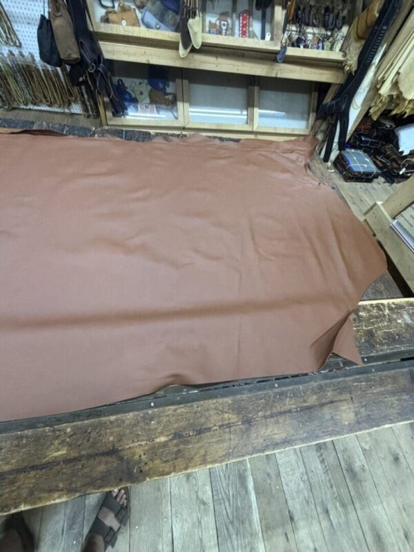 Large brown leather sheet on wood floor.