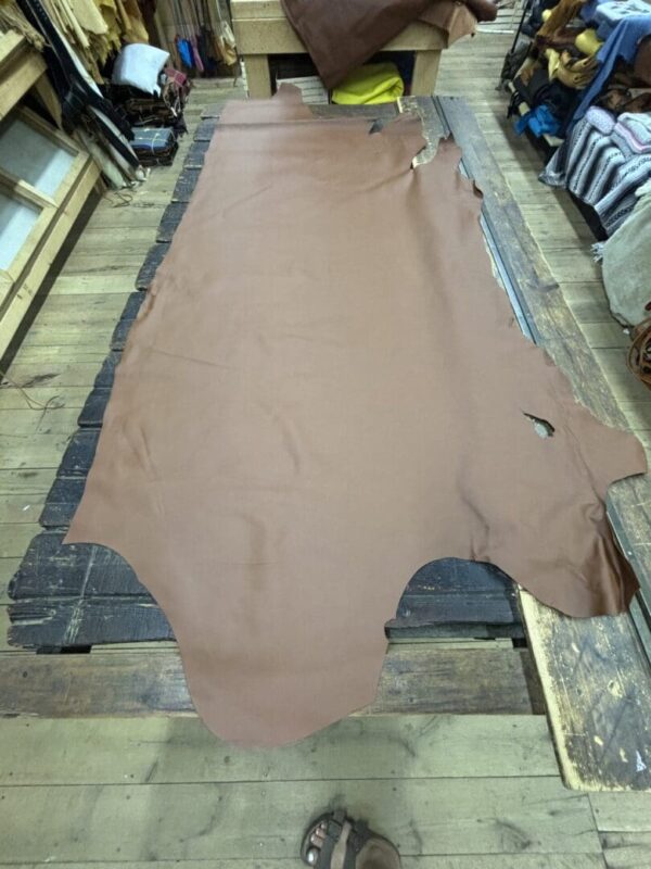 Brown leather hide on wooden table.