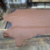 Brown leather hide on wooden floor.