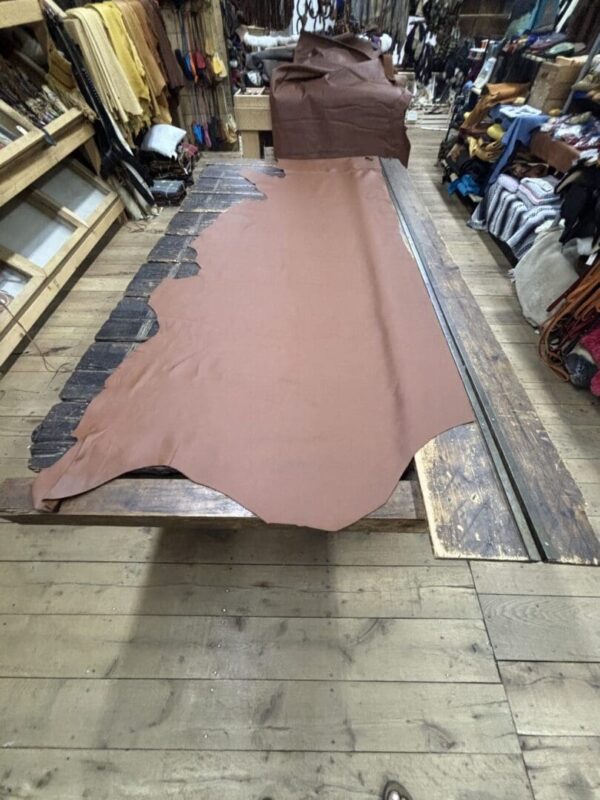 Large brown leather hide on table.